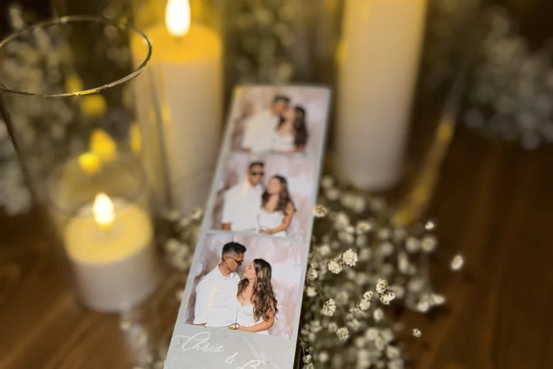 A printed photo strip resting among candles and baby's breath